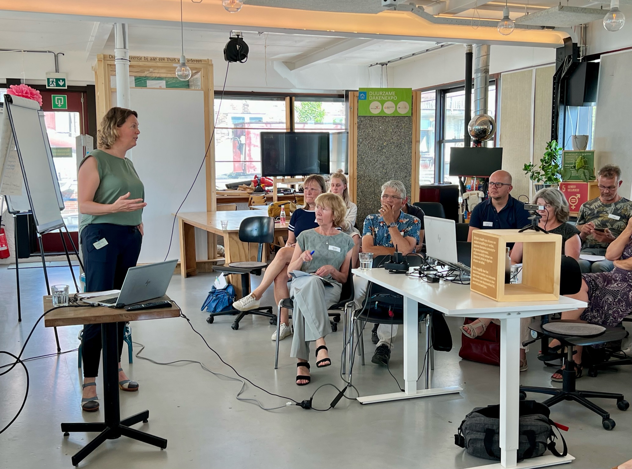 Maaike van Zijverden staat voor een zaal met deelnemers te spreken.