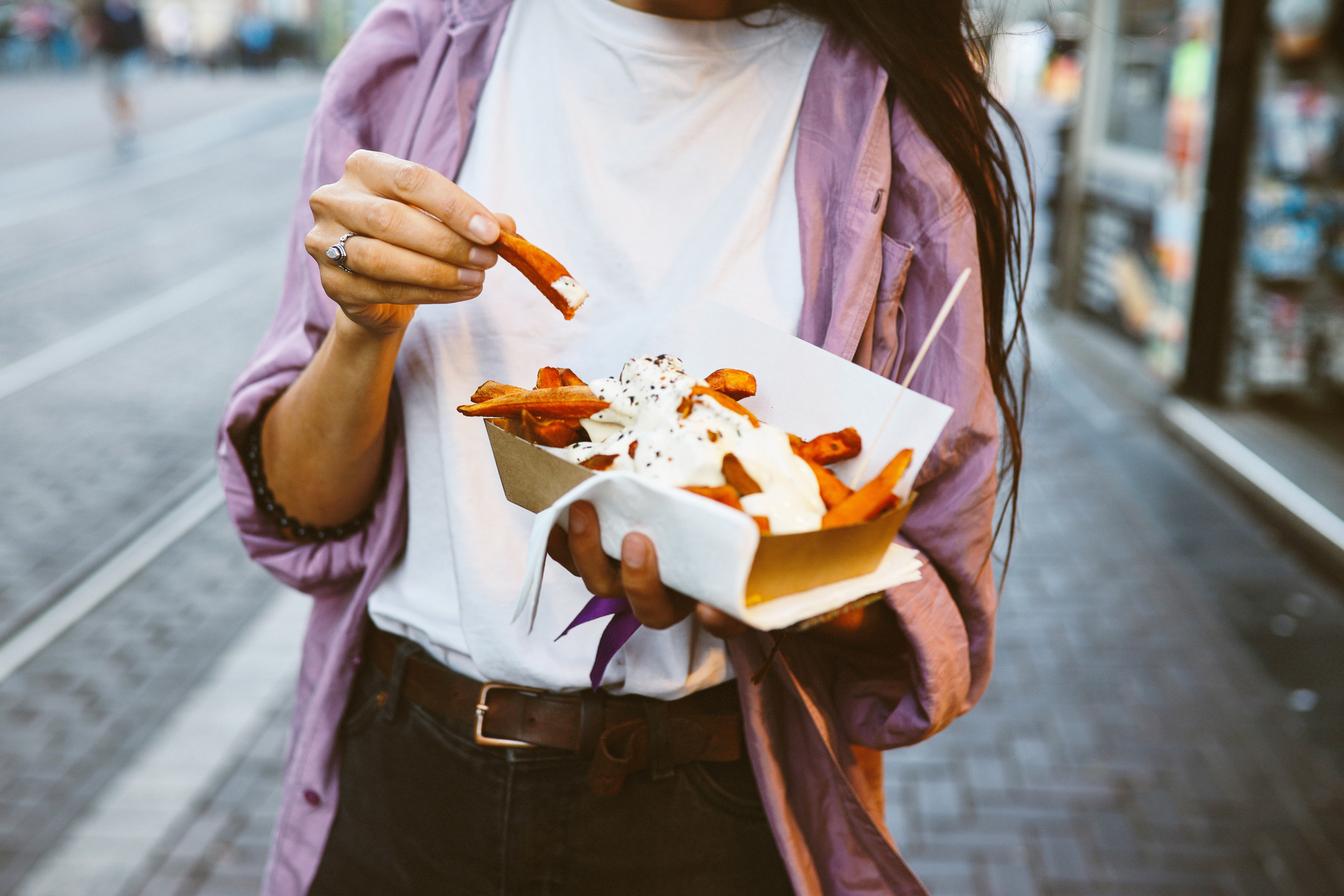 Vrouw eet patat op straat