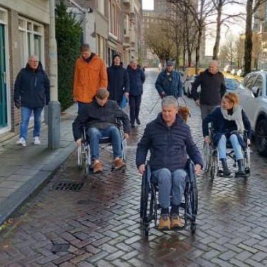 Een groep mensen zit in een rolstoel om te ervaren hoe het is om zich door de stad te verplaatsen