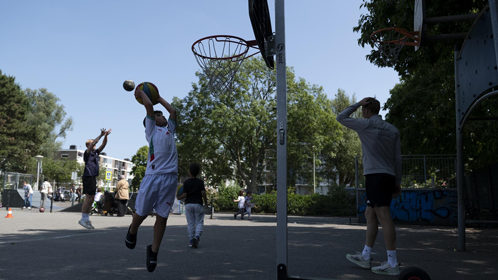 kinderen spelen basketbal op een basketbalveld