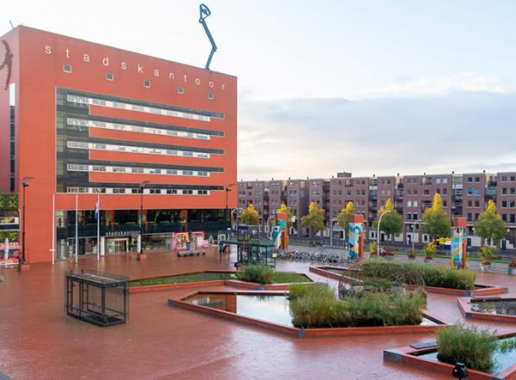 Het rode Lübeckplein in Zwolle na aanpassingen. Je ziet meer groen en mogelijkheid voor ontspanning en activiteiten op het plein dat voorheen alleen uit steen bestond.