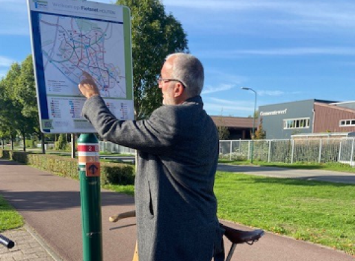 Man met fiets wijst op de kaart