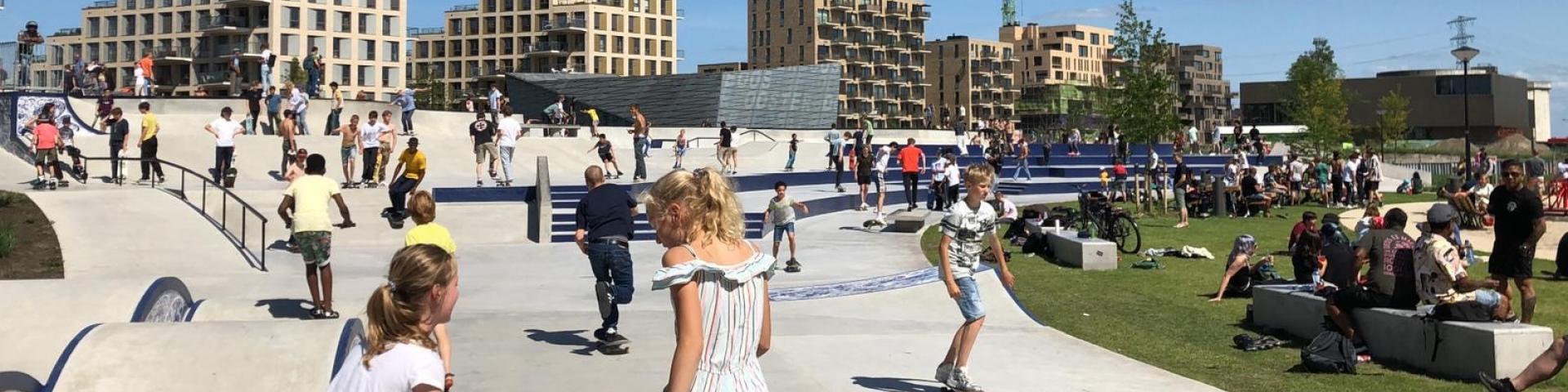 Veel kinderen zijn aan het recreeeren in het zeeburgereiland skatepark in Amsterdam