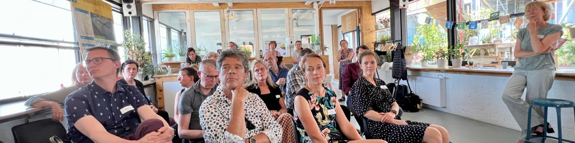 Aantal deelnemers luisteren naar mensen in de zaal tijdens de discussie