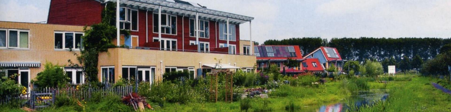 Duurzaam ecologisch wonen in Culemborg, rode huizen aan het water met veel groen afgebeeld.