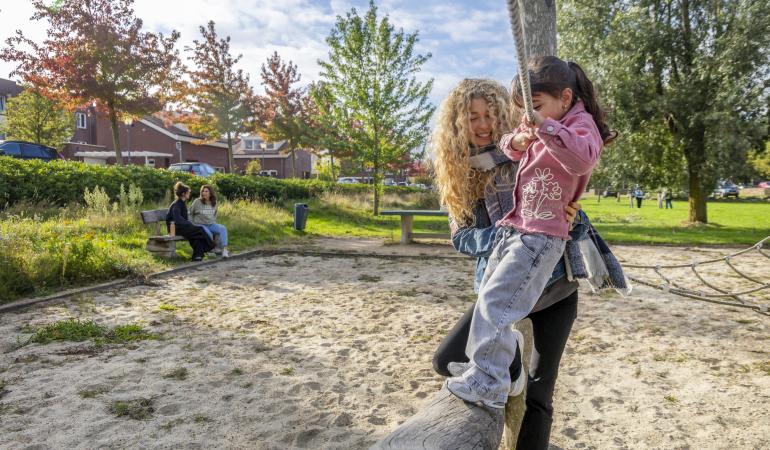 Kind en volwassene spelen in een klimrek