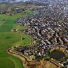 Een luchtfoto van De Dommel, een beek stroomafwaarts een kleinere rivier in de Kempen en de Meierij van 's-Hertogenbosch. Je ziet een stuk platteland en stad.